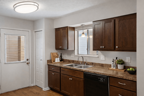 Grand Rapids townhouse for rent - A kitchen with brown cabinets and a black dishwasher.