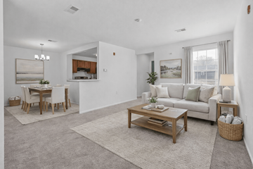 Canton apartment for rent - A living room with a white couch, a wooden coffee table, and a dining table with chairs.