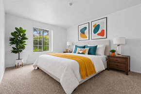 Canton townhouse for rent - A bedroom with a large bed, a plant, and two framed pictures on the wall.