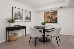 Detroit apartment for rent - A black and white framed picture hangs on a white wall above a black desk with a plant on it.