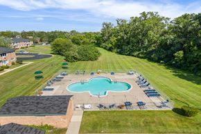 Plymouth apartment for rent - an aerial view of a pool and lawn with chairs around it