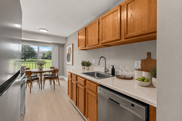 Troy apartment for rent - A kitchen with wooden cabinets and a stainless steel dishwasher.