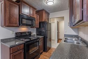 Lansing apartment for rent - a kitchen with black appliances and granite counter tops