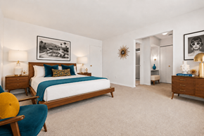 Southfield apartment for rent - A bedroom with a bed, two nightstands, a chair, and a framed picture on the wall.