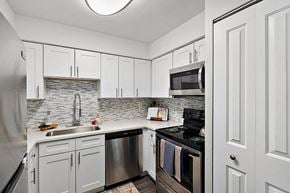 Riverview apartment for rent - a kitchen with stainless steel appliances and white cabinets