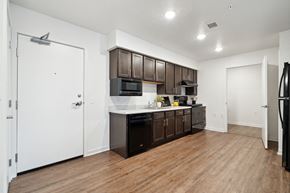 Marion apartment for rent - a kitchen with dark wood cabinets and white countertops and a refrigerator