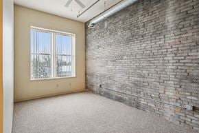 Clinton apartment for rent - A room with a brick wall and a window with a view of trees.
