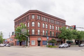 Clinton apartment for rent - A large red brick building with a green awning sits at a street corner.