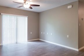 North Liberty apartment for rent - A room with a ceiling fan and a window with blinds.