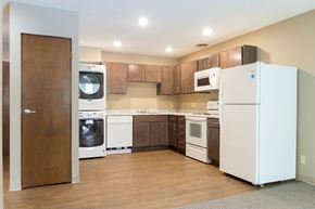Spencer apartment for rent - a kitchen with brown cabinets and white appliances