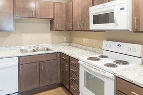Spencer apartment for rent - a kitchen with white appliances and brown cabinets
