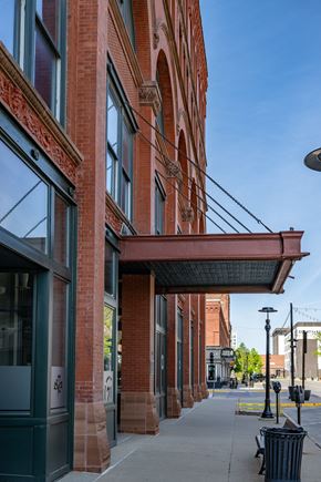 Sioux City apartment for rent - A red brick building with a black trash can in front of it.