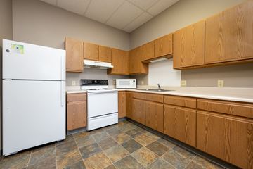 Sioux City apartment for rent - A kitchen with wooden cabinets and a white refrigerator.