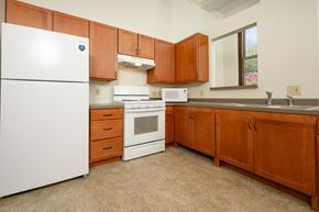 Sioux City apartment for rent - A kitchen with brown cabinets and white appliances.