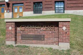 Sioux City apartment for rent - A brick wall with a sign that says Carnegie Place Apartments.