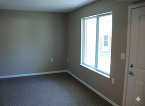 Columbus Junction apartment for rent - A room with a carpeted floor and a window letting in sunlight.