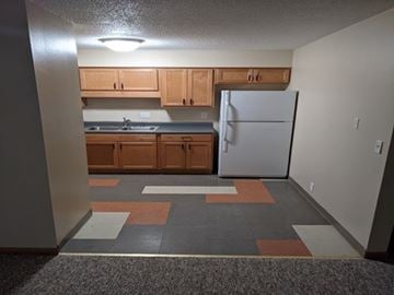 Forest City apartment for rent - A kitchen with a white refrigerator and wooden cabinets.