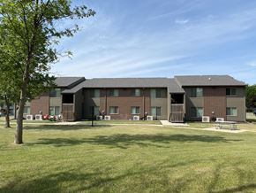 Forest City apartment for rent - A large building with a green lawn in front.