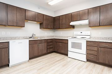 Sioux City apartment for rent - A kitchen with white appliances and brown cabinets.