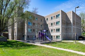 Sioux City apartment for rent - A playground with purple slides is in front of a brick building.