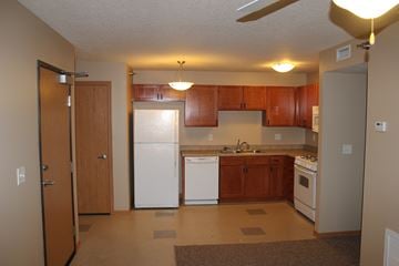 Ames townhouse for rent - A kitchen with white appliances and wooden cabinets.