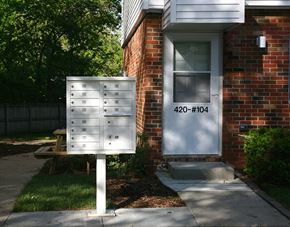 Ames townhouse for rent - A white mailbox with the number 420-104 on it is in front of a brick house.