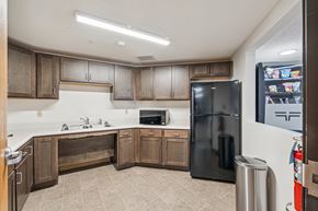 Des Moines apartment for rent - A kitchen with a black refrigerator and wooden cabinets.