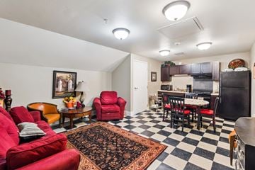 Oskaloosa apartment for rent - A living room with red chairs and a black and white checkered floor.