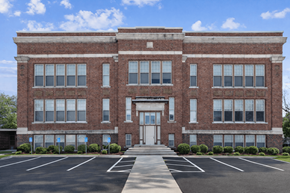 Oskaloosa apartment for rent - A large red brick building with a white door and windows.
