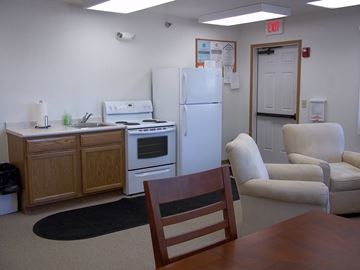 Webster City apartment for rent - A kitchen with a refrigerator, oven, and a table with a chair.