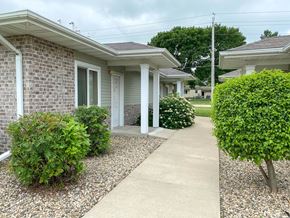 Webster City apartment for rent - A residential area with a house, bushes, and a gravel path.