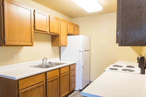 Spirit Lake apartment for rent - A kitchen with wooden cabinets and a white refrigerator.