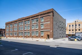 Sioux City apartment for rent - A large brick building with a parking lot in front.