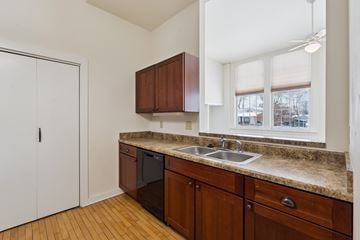 Oskaloosa apartment for rent - A kitchen with brown cabinets and a black dishwasher.
