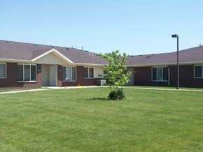 Sioux Center apartment for rent - A small tree is in front of a building with a brown roof.