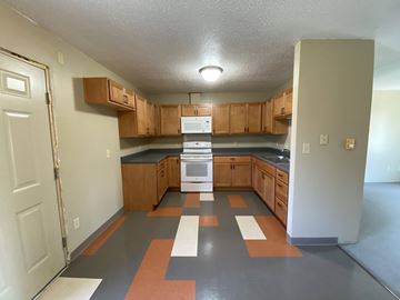 Sheldon apartment for rent - A kitchen with wooden cabinets and a black countertop.