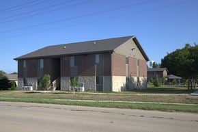 Sheldon apartment for rent - A large brick building with a grey roof and a small porch.