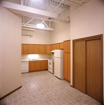 Mason City apartment for rent - A kitchen with wooden cabinets and white appliances.
