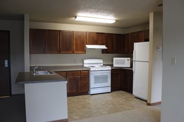 Milford apartment for rent - A kitchen with white appliances and brown cabinets.