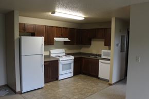 Milford apartment for rent - A kitchen with white appliances and brown cabinets.