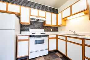 Sioux City apartment for rent - A kitchen with white appliances and wooden cabinets.