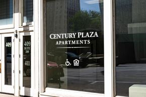 Sioux City apartment for rent - A glass door with Century Plaza Apartments written on it.