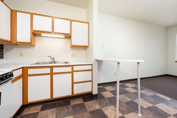 Sioux City apartment for rent - A kitchen with white cabinets and a checkered floor.