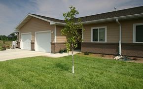 Council Bluffs apartment for rent - A small tree in front of a house.