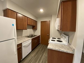 Spencer apartment for rent - A kitchen with a white stove top oven and white appliances.