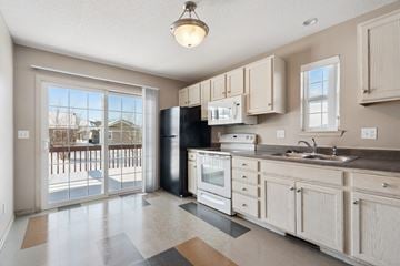 Cedar Rapids apartment for rent - A kitchen with a black refrigerator and white cabinets.
