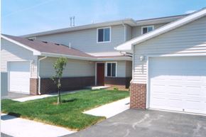 Council Bluffs apartment for rent - A house with a garage and a tree in front.