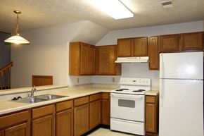 Council Bluffs apartment for rent - A kitchen with white appliances and wooden cabinets.
