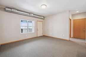 Clinton apartment for rent - A room with a window, two doors, and a carpeted floor.