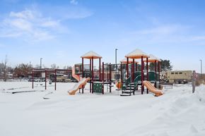 Clinton apartment for rent - A playground with a yellow slide and a red roofed structure.